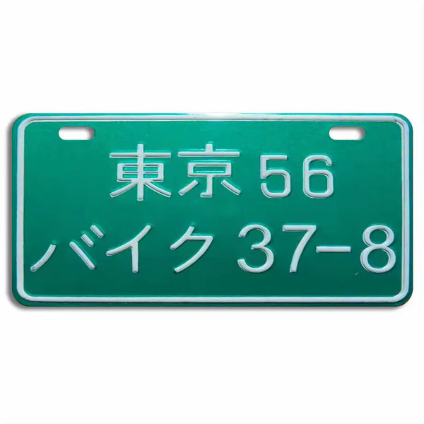 A green Japanese motorcycle license plate with white characters.