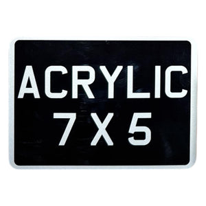 An acrylic motorcycle number plate with the text 'ACRYLIC 7X5' in bold white letters on a black background, simulating a classic vintage style.
