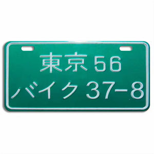 A green Japanese motorcycle license plate with white characters.