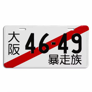 A novelty license plate featuring a white background with black Japanese characters, the numbers 46-49 in black, and a bold red diagonal stripe across the plate.