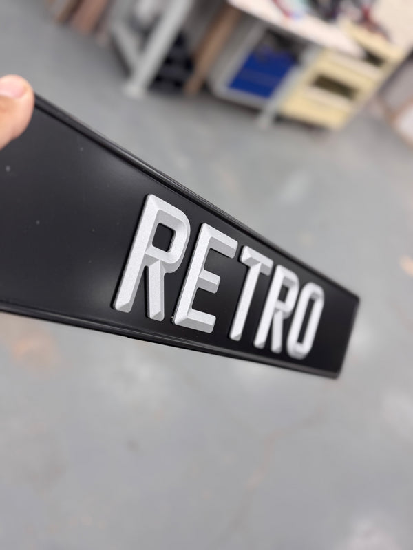 black and silver number plate stamped with the raised word 'retro'